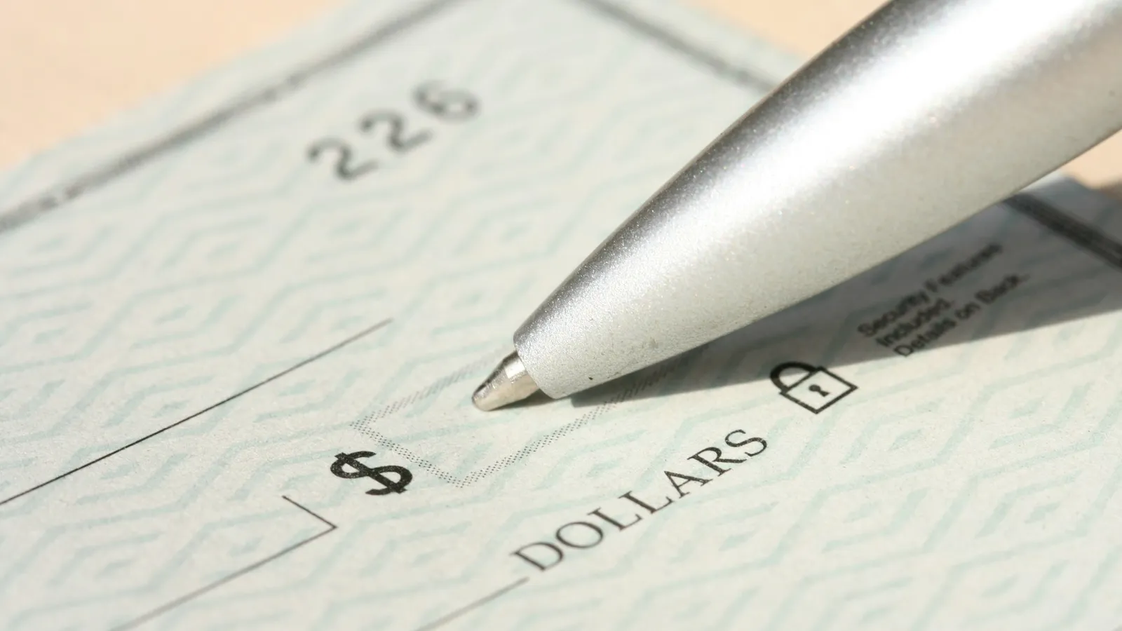 Pen resting on a blank cheque, collecting a bounced cheque in Mexico