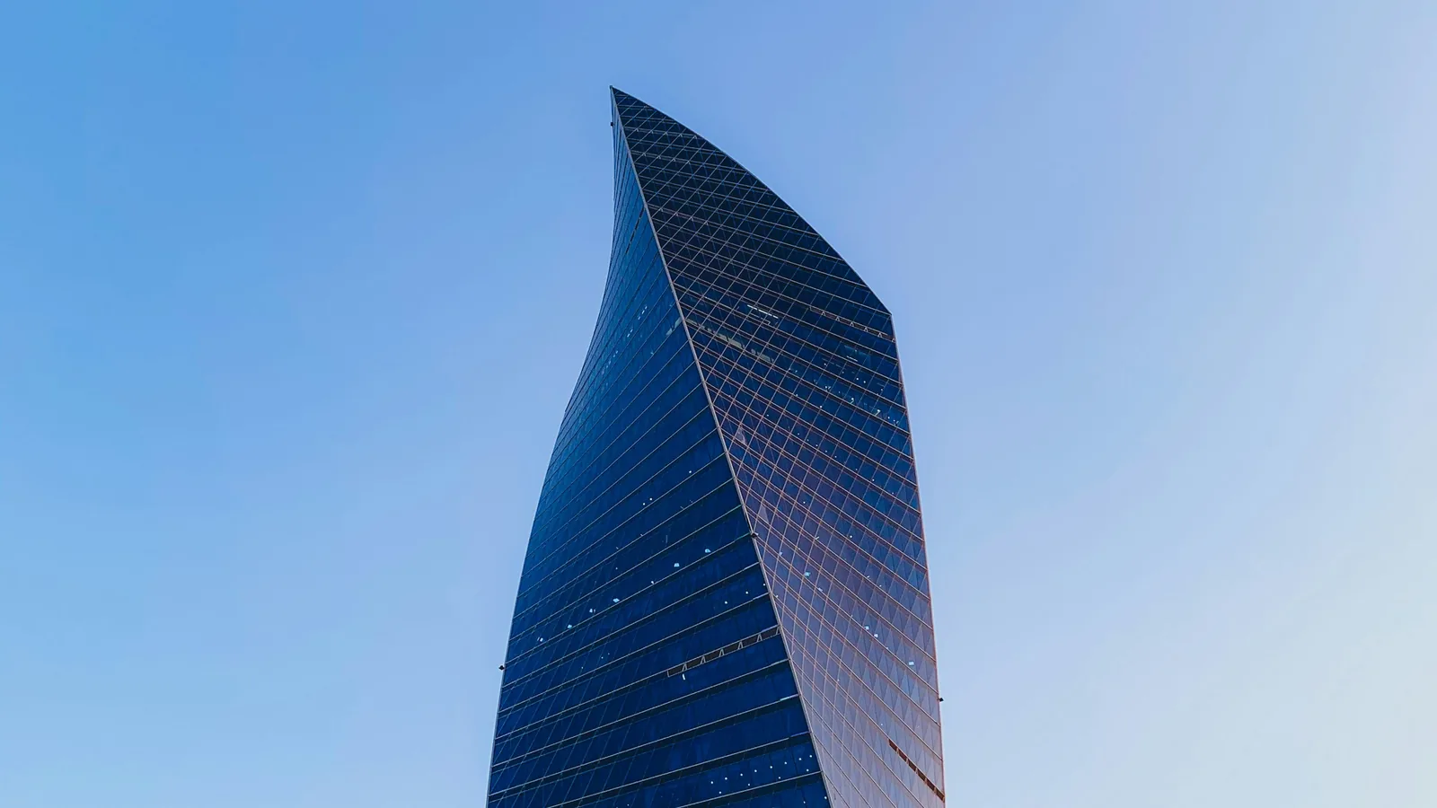 Modern glass office tower against a blue sky, corporate legal counsel in Guadalajara